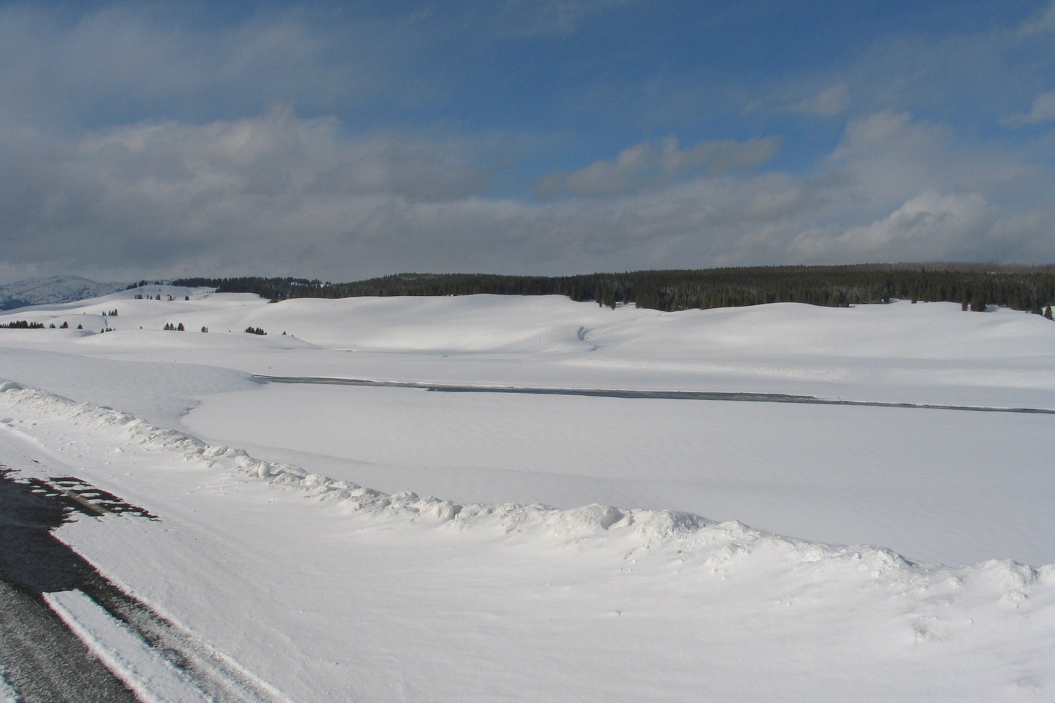 The Hayden Valley under snow, the course of the river showing dark through the white.